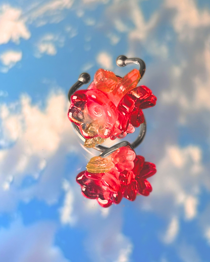 Red glass flower with a blue sky and white clouds in the background